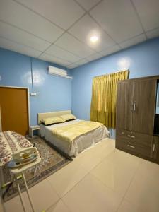 a bedroom with a bed and a cabinet and a table at Tanjung Pagar Homestay 3 Bilik Tidur, 2 Bilik Air in Kampong Nibong