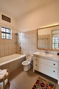 a bathroom with a tub and a toilet and a sink at Cozy Stays Kigali in Kigali