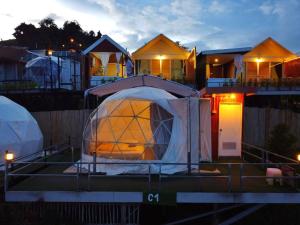a large dome tent in front of a row of houses at อาฉ่างแคมป์ Achang Camp in Mon Jam