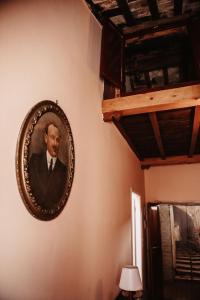 Ein Bild eines Mannes, der an einer Wand hängt. in der Unterkunft Palazzetto Pergi in Tolfa