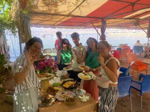 a group of people standing around a table with food at Al-Amer Hostel 2 in Aqaba