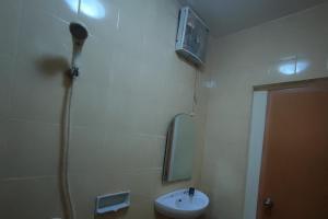 a bathroom with a shower and a sink and a mirror at OYO 93252 Garuda Bandara Guesthouse in Palembang