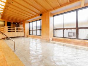 Habitación vacía con ventanas y suelo de agua en Yukai Resort Saichoraku, en Kaga