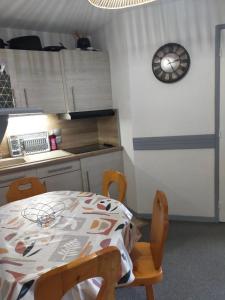 a kitchen with a table and a clock on the wall at Appartement Manigod/La clusaz in Manigod