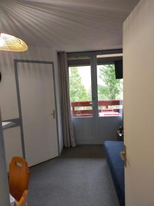 een kamer met een deur en een kamer met een balkon bij Appartement Manigod/La clusaz in Manigod