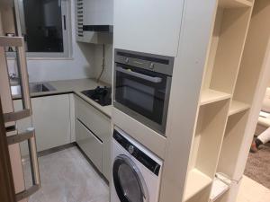 a kitchen with a stove and a washer and dryer at Sapphire Asta- Regent Hills in Mumbai
