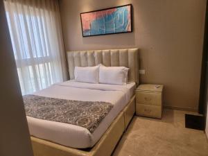 a small bedroom with a bed with white sheets at Sapphire Asta- Regent Hills in Mumbai