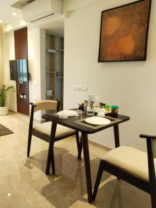 a dining room with a table and two chairs at Sapphire Asta- Regent Hills in Mumbai