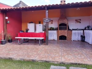 une terrasse avec une table et une cuisine dans une maison dans l'établissement Aconchego da Vovó, à Araruama