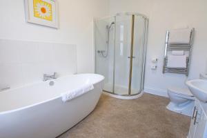 a bathroom with a tub and a shower and a toilet at The Grosvenor Plymouth in Plymouth +31 photos