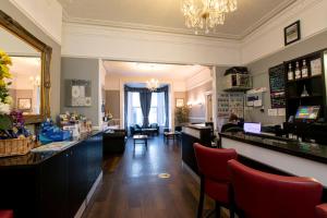 a salon with a bar with red chairs in a room at The Grosvenor Plymouth in Plymouth