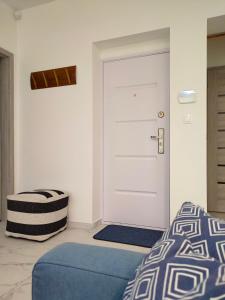 - une chambre avec un lit et une porte blanche dans l'établissement Pe-Ki Apartman Székesfehérvár, à Székesfehérvár