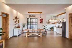 a dining room with a table and a kitchen at Cozy Stays Kigali in Kigali