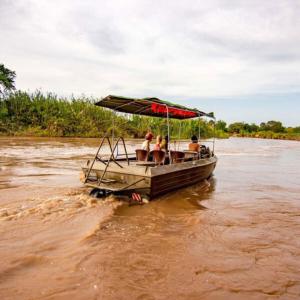 een groep mensen op een boot op een rivier bij Nje Bush Camp in Kwangwazi