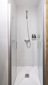 y baño con ducha y puerta de cristal. en La posada de Calixto, en Valdepeñas