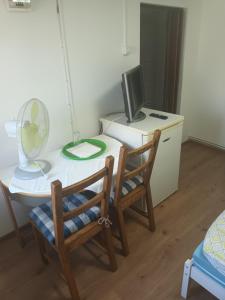 Zimmer mit einem Schreibtisch mit einem Computer und 2 Stühlen in der Unterkunft Camera con bagno in Ploieşti