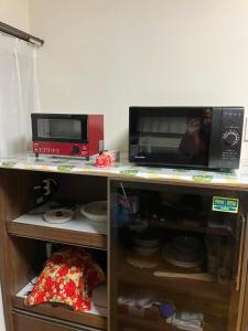 a microwave and a toaster oven on a shelf at 民泊　筑紫野 in Chikushino