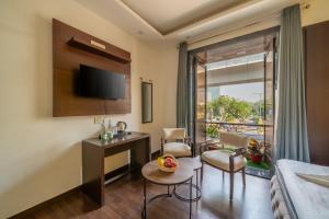 - un salon avec un canapé, un bureau et une fenêtre dans l'établissement Lime Boutique Bed & Breakfast -Near Eros Hotel Nehru Place Metro, à New Delhi
