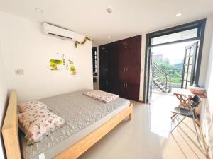 a bedroom with a bed and a large window at Kemnpi Homestay in Hue