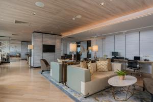 an office lobby with a couch and tables and chairs at Holiday Inn & Suites Rayong City Centre, an IHG Hotel in Rayong