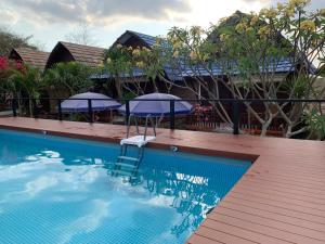 una piscina con una silla y sombrillas en Tanah Penida Bungalows, en Nusa Penida