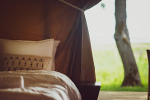 a bed with a pillow in front of a window at Mia Glamping in Orissaare