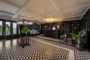 a hotel lobby with a reception desk and flowers at Genesis Luxury Regal Cruises in Ha Long