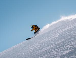 a person is snowboarding down a snow covered slope at Revier Mountain Lodge Lenzerheide in Lenzerheide