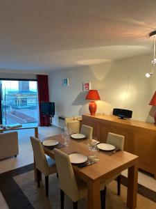 comedor con mesa de madera y sillas en appartement Lichttorenplein met garage, en Knokke-Heist