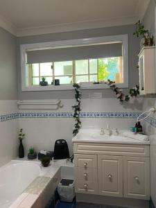 a bathroom with a tub and a sink and a window at Rocky Rest in Orange +87 photos