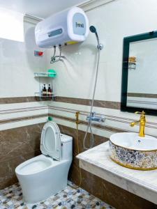 a bathroom with a toilet and a sink at HagiangGo Hostel-Motorbikes rental and Tour in Ha Giang