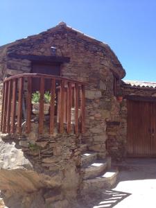 a stone building with a wooden gate and stairs at Casa Da Pena in Góis