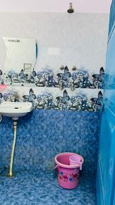 a blue bathroom with a sink and a bucket at Mayur Guest House in Pushkar