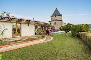 a house and a church with a grass yard at Villa Les Lys - Avec piscine et grand jardin in Sames
