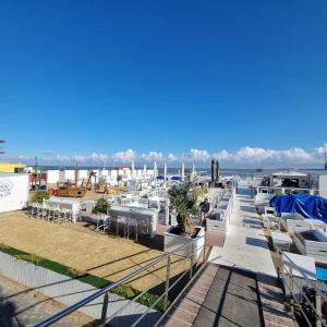 une rangée de tables et de chaises blanches sur un balcon dans l'établissement appartement Lichttorenplein met garage, à Knokke-Heist