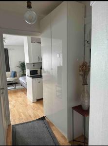 ein Wohnzimmer mit einem weißen Kühlschrank und eine Küche in der Unterkunft Amazing Studio by Royal Palace in Oslo