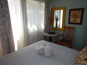 een slaapkamer met een bed met handdoeken erop bij Solitaire Guest Apartments in Pretoria