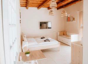 a white living room with a couch and a table at Ako doma in Poltár