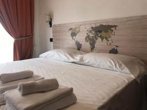 a bed with towels on it with a map on the wall at EURO HOUSE INN airport in Fiumicino