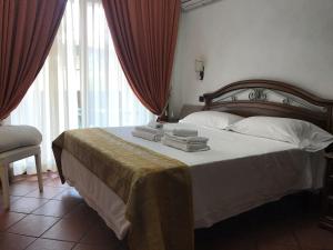 a bedroom with a large bed with towels on it at EURO HOUSE INN airport in Fiumicino