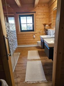een badkamer met 2 wastafels, een toilet en een raam bij Blockhaus im Süden Deutschlands in Höchenschwand
