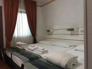 a bedroom with two beds with white towels on them at EURO HOUSE INN airport in Fiumicino