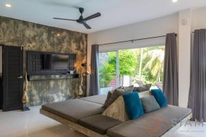 a living room with a couch and a tv at OG Villa & Private Pool in Koh Samui