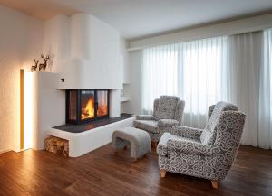 a living room with two chairs and a fireplace at Residence Eden in Arosa