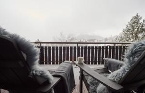 einen Balkon mit 2 Stühlen und einem Tisch mit einer Tasse Kaffee in der Unterkunft Residence Eden in Arosa