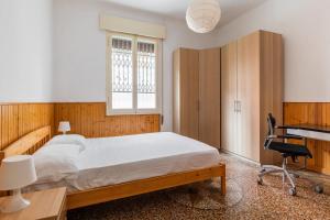 Schlafzimmer mit einem Bett, einem Schreibtisch und einem Stuhl in der Unterkunft Sant'Orsola Apartment by Wonderful Italy in Bologna