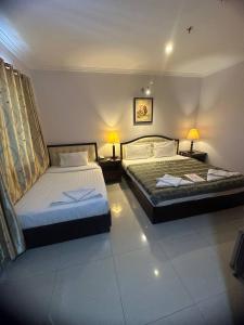 1 dormitorio con 2 camas y 2 lámparas en las mesas en Silver Mounts Hotel en Phnom Penh