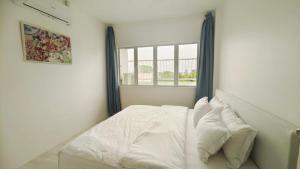 uma cama branca num quarto com uma janela em ALVILLA - Jalan Sultan Ismail em Kuala Terengganu