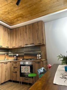 cocina con armarios de madera y mesa de madera con mesa en WoodStar, en Ambrolauri