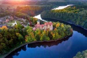 an island in the middle of a lake with a castle at Zamek Czocha in Leśna